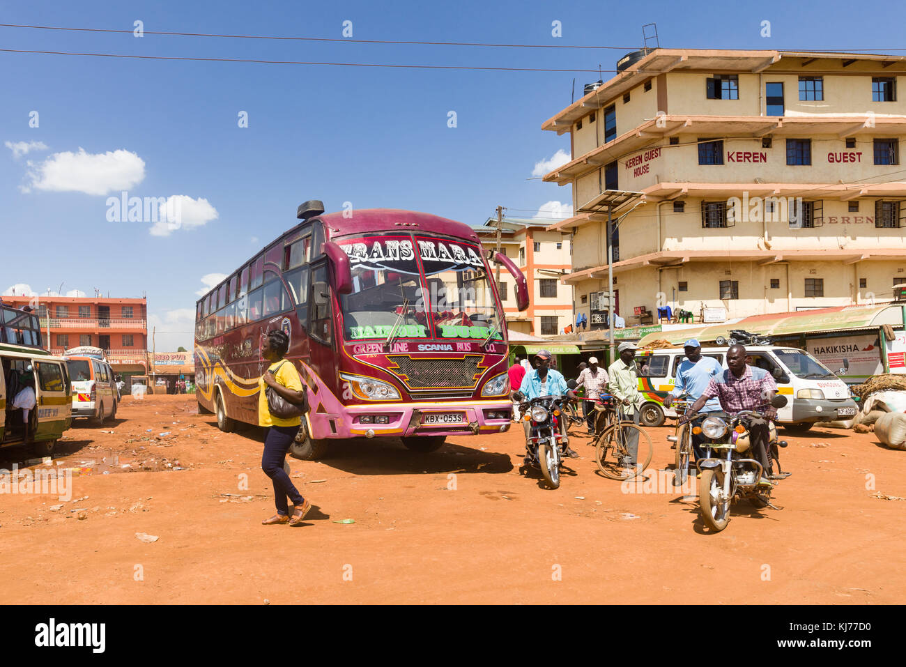 .Un bus garé joliment décorées par la route dans une ville animée avec des personnes conduite motos passé, l'Ouganda, l'Afrique Banque D'Images