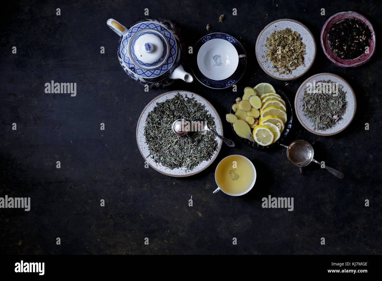 Différentes feuilles de thé avec des tranches de citron sur fond sombre Banque D'Images