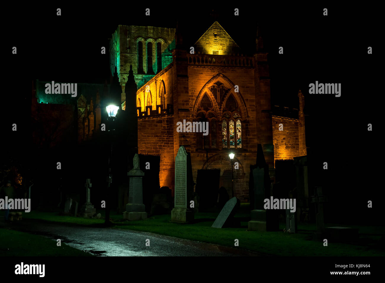 St Mary's Collegiate Church, Haddington, East Lothian, Scotland, UK, de nuit avec des pierres tombales et le cimetière, et grand vitrail éclairé Banque D'Images