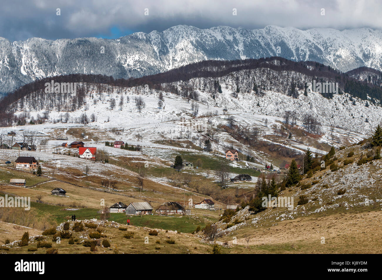 Hiver paysage rural traditionnel avec des maisons de ferme près de Piatra Craiului massif à Sirnea village, Brasov, Roumanie. Banque D'Images