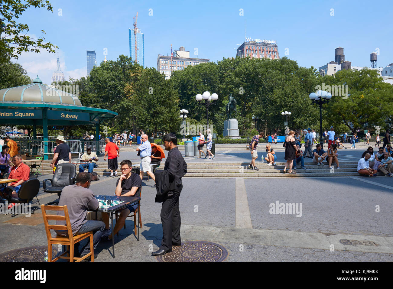 Union Square avec des joueurs d'échecs et de gens assis sur les étapes d'une journée ensoleillée à New York Banque D'Images