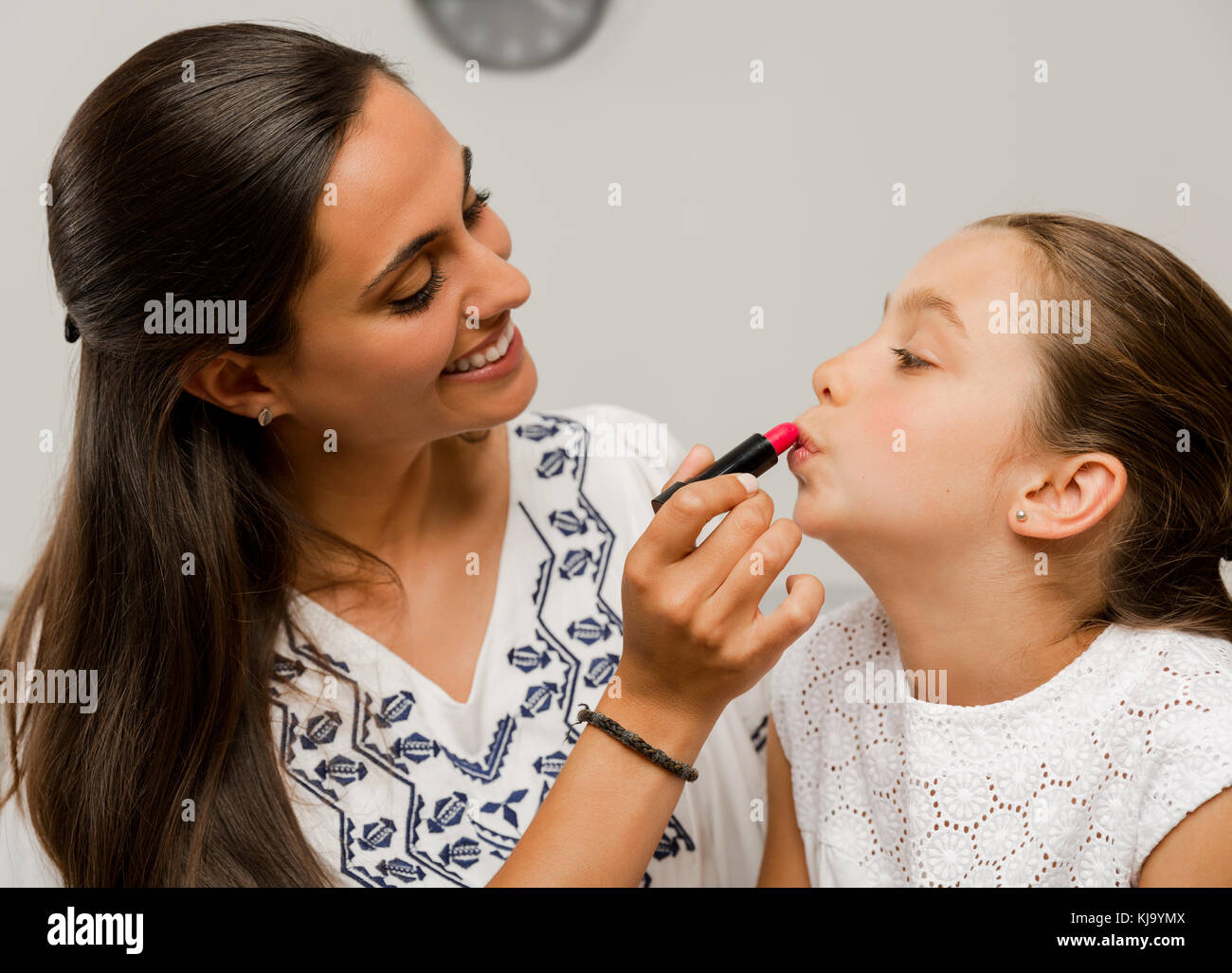 Jouant avec sa fille mère appliquer le rouge à lèvres Banque D'Images