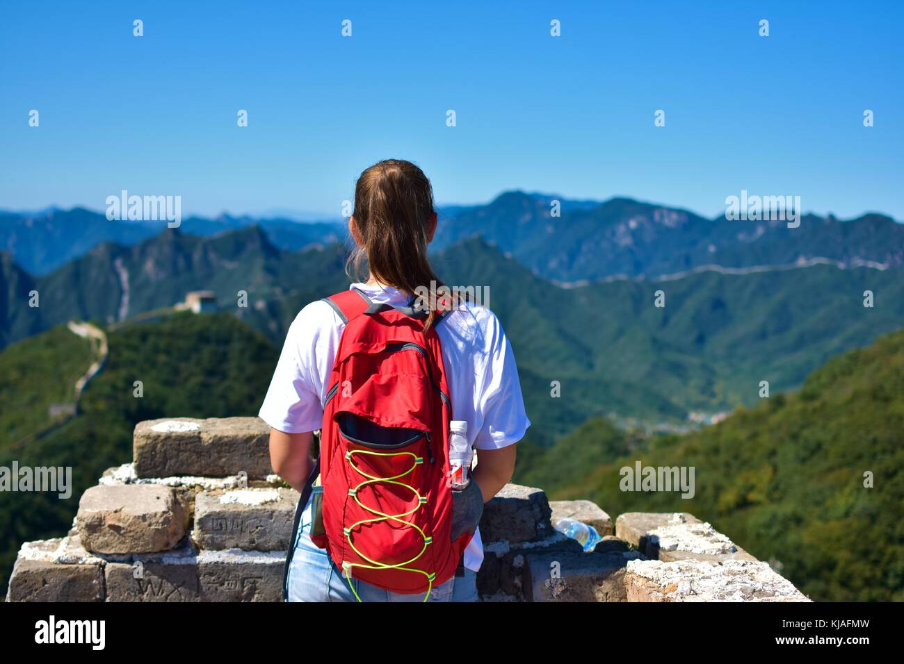 La surveillance d'une femme de la grande muraille de Chine, à jiankou, portant un sac rouge. Banque D'Images