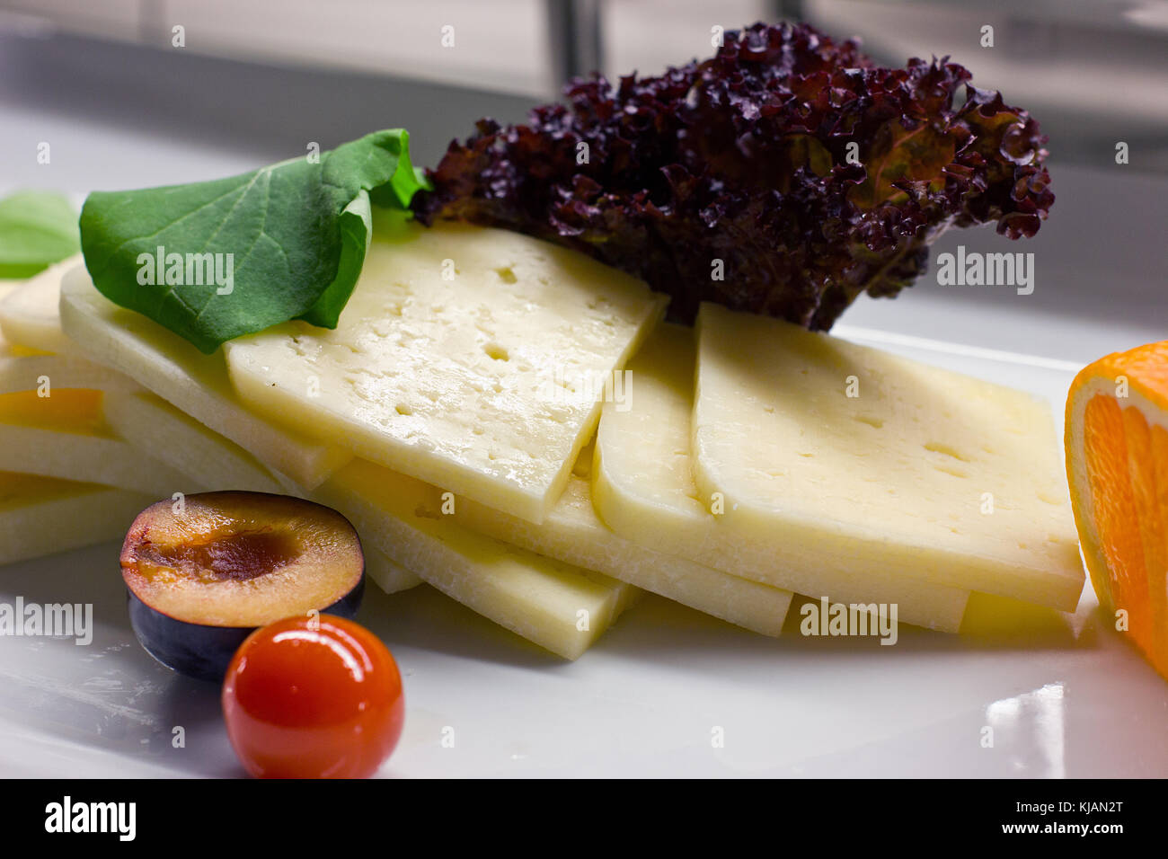 Le fromage cheddar avec quelques herbes fraîches, de prune et de tomates cerises Banque D'Images