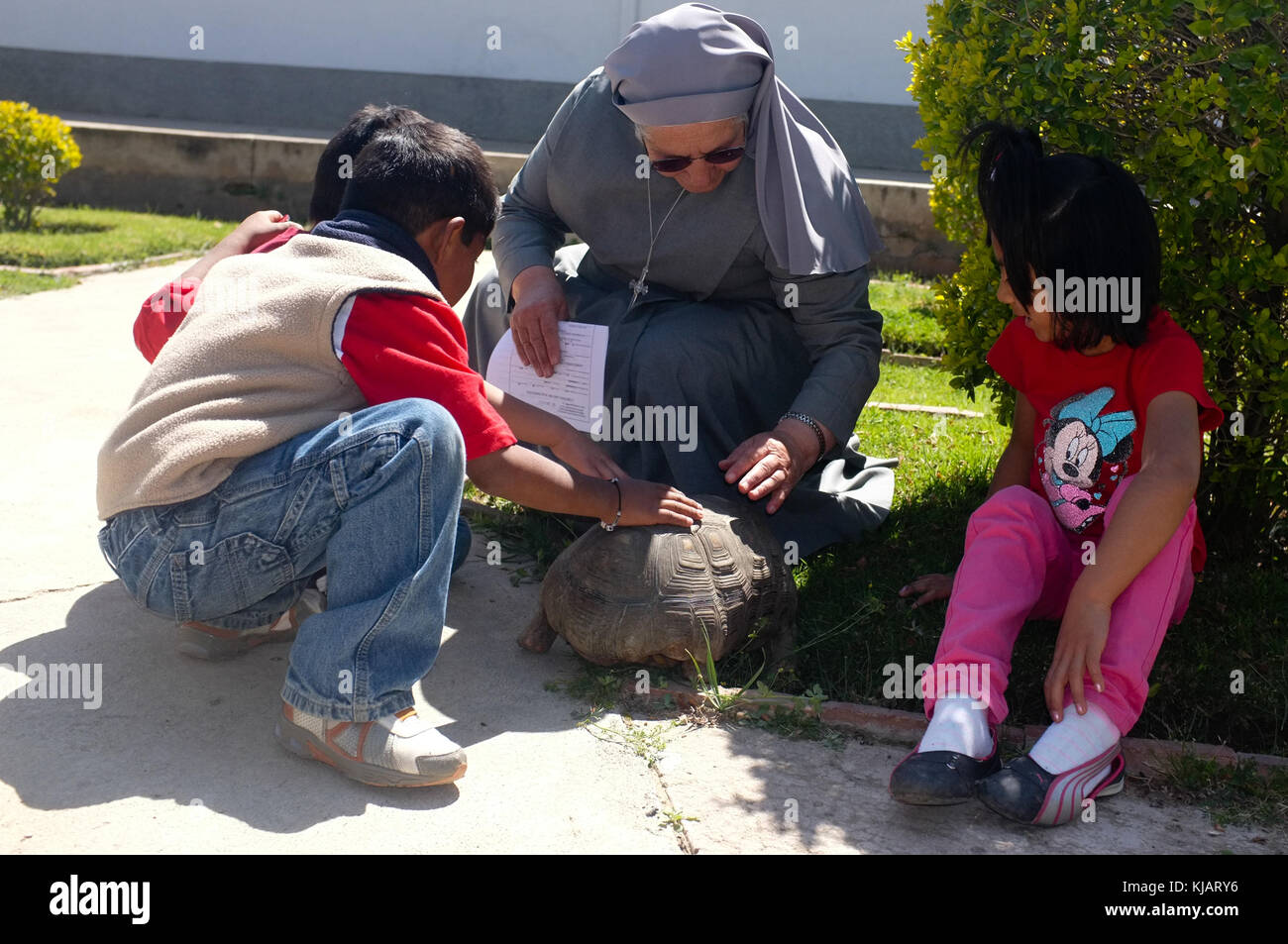 Nun responsable de l'adoption internationale s'amusant piscine avec certains enfants. L'Ordre des moniales oblates Mission. Cochabamba, Bolivie. Banque D'Images