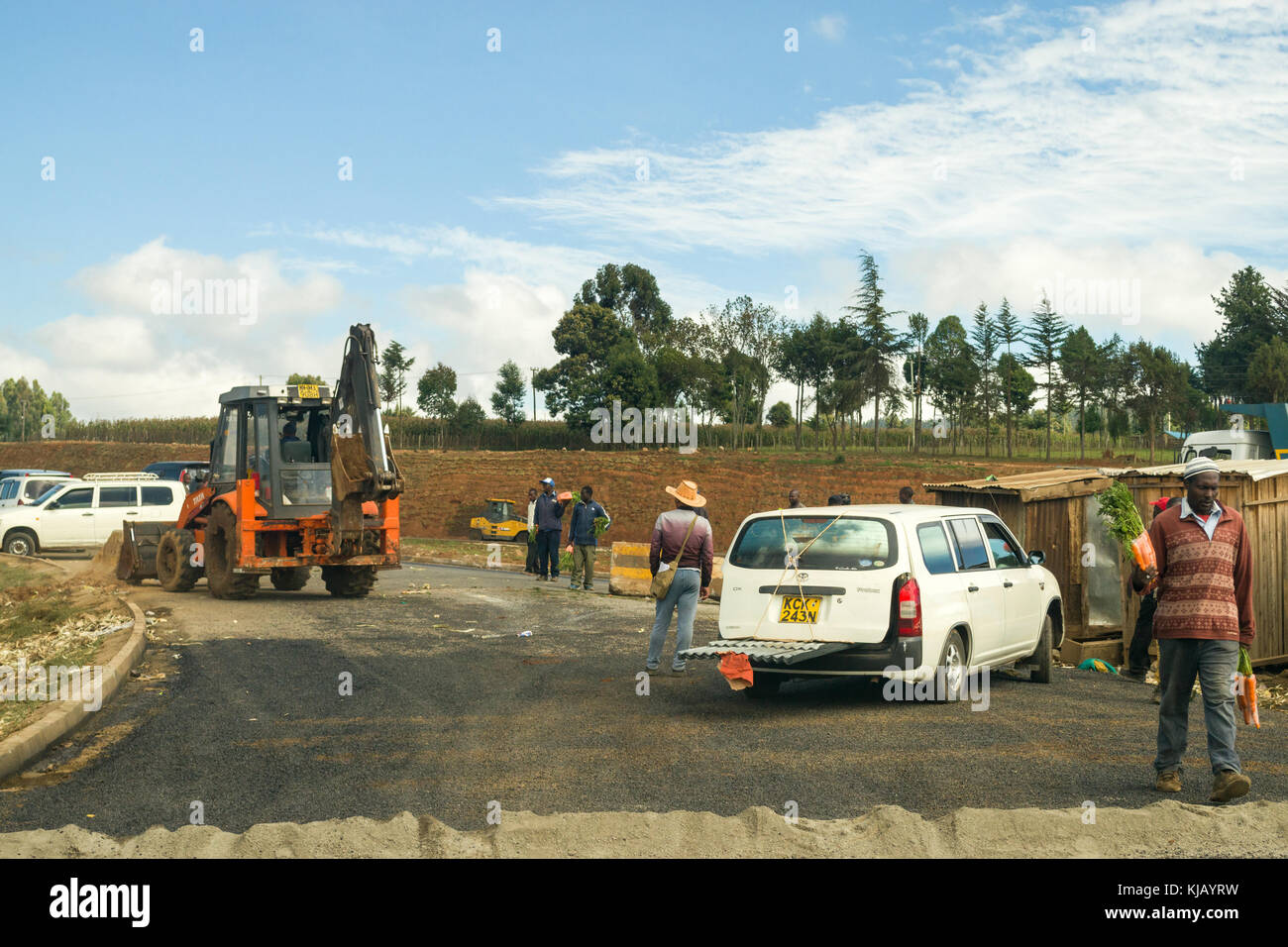 De construction lourde, de machines sur l'autoroute en construction avec des personnes et des véhicules sur elle, Kenya, Afrique de l'Est Banque D'Images