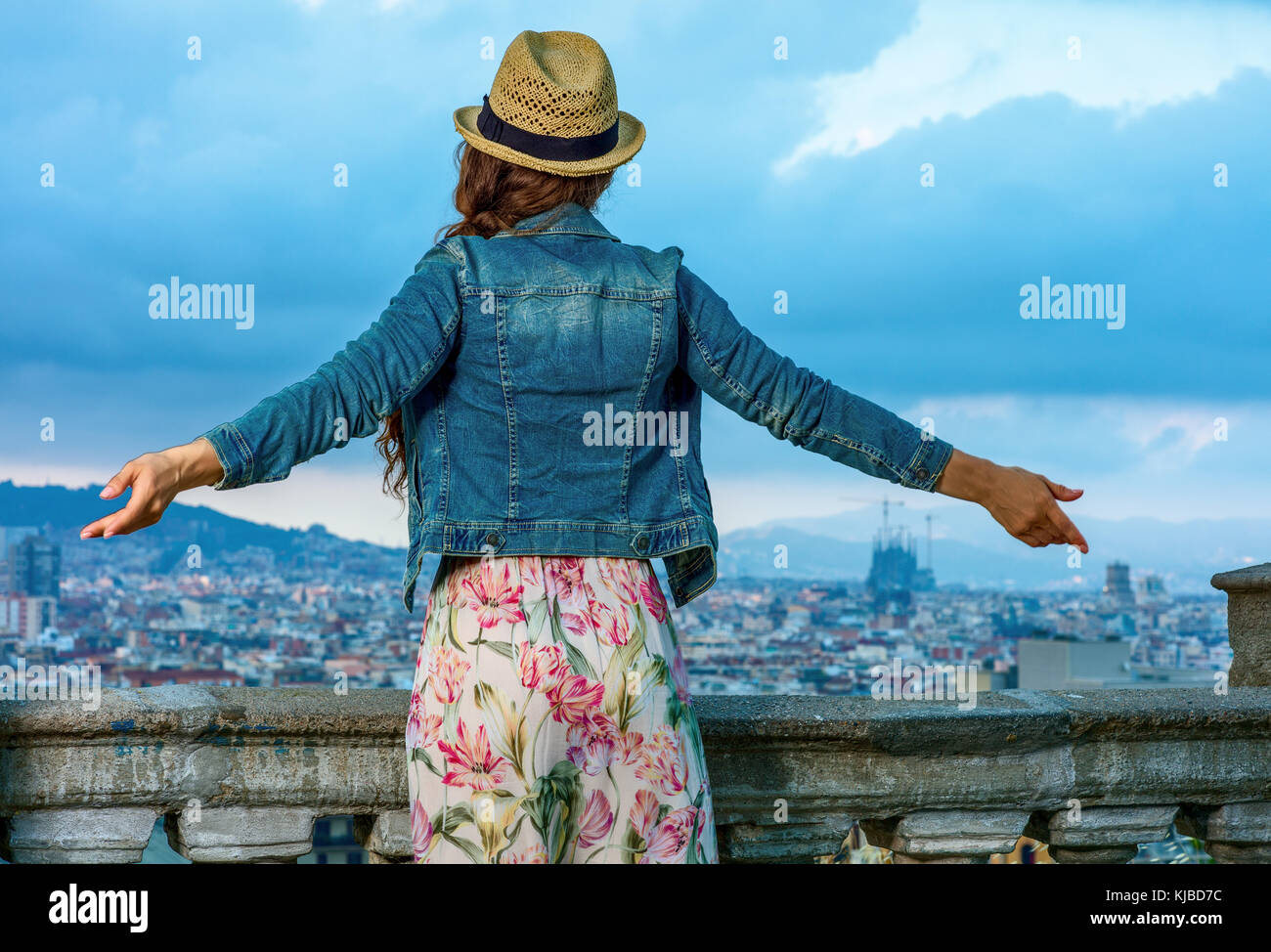 Soirée parfaite avec vue magnifique. vu de dos trendy femme en robe et  chapeau de paille dans l'avant du paysage urbain de Barcelone, Espagne  réjouissance Photo Stock - Alamy