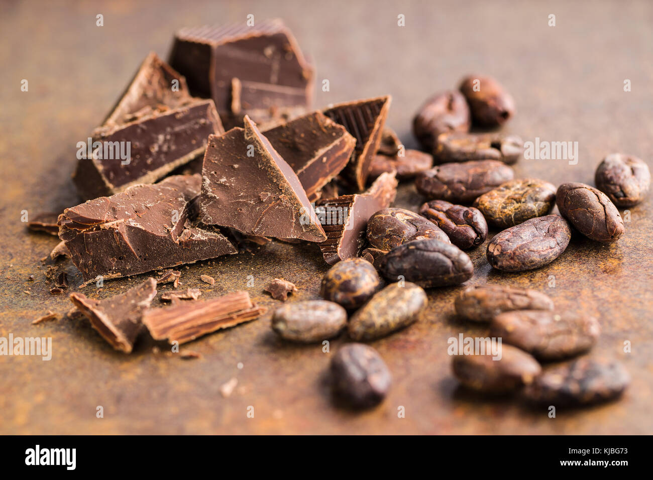 Le chocolat noir et fèves de cacao. Le chocolat sucré sur old rusty arrière-plan. Banque D'Images