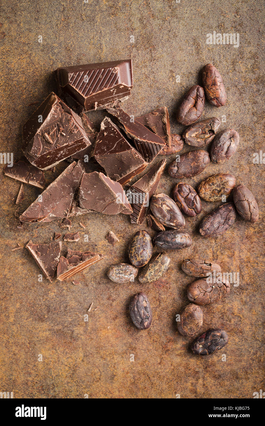 Le chocolat noir et fèves de cacao. Le chocolat sucré sur old rusty arrière-plan. Banque D'Images