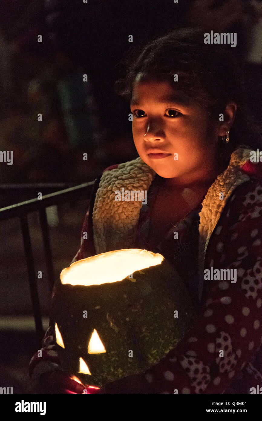 Une jeune fille indigène de Purepecha tient une citrouille sculptée pendant le festival Day of the Dead au cimetière Mirador Del Panteon le 1er novembre 2017 à l'île Janitzio, Michoacan, Mexique. Le festival a été célébré depuis que l'empire aztèque célèbre les ancêtres et les proches décédés. Banque D'Images
