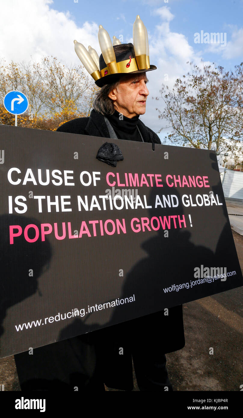 Bonn, Allemagne, le 17 novembre 2017 : un homme à condom hat détient une bannière avertissement sur la croissance de la population en face de lors de la COP 23 confère au changement climatique Banque D'Images