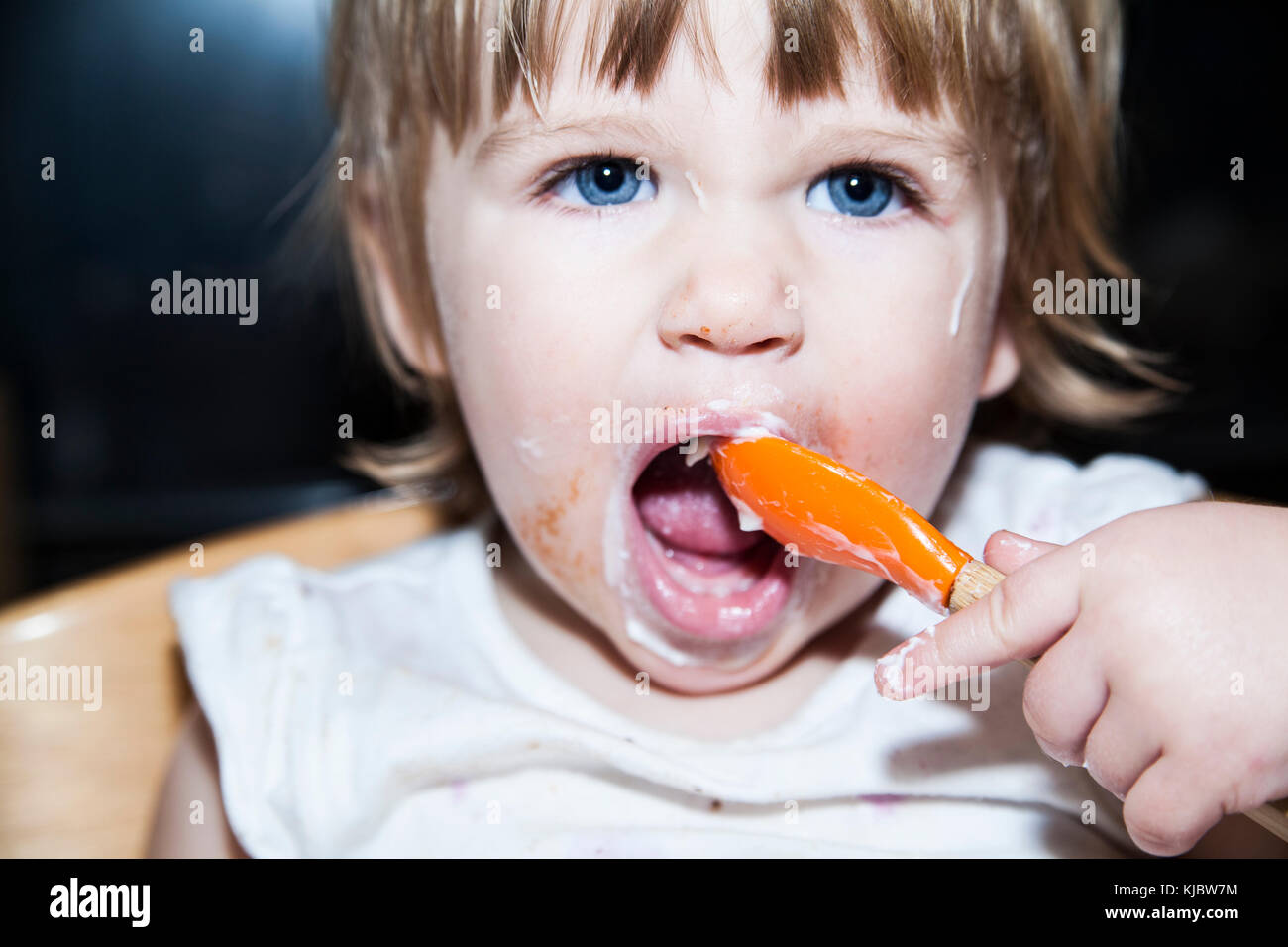Enfant malpropre de manger avec une cuillère Banque D'Images
