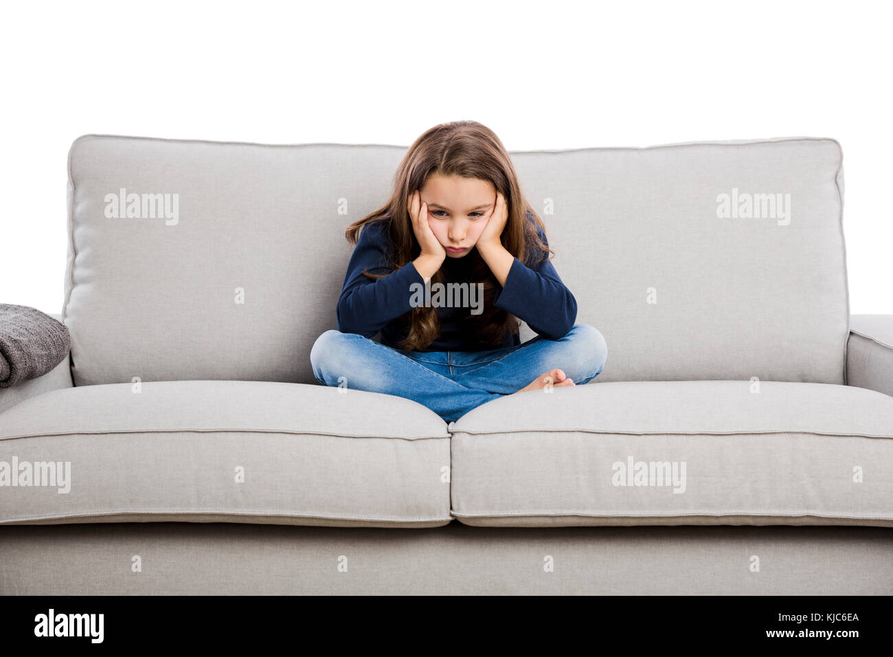 Petite fille assise sur un canapé et contrarié par quelque chose Banque D'Images