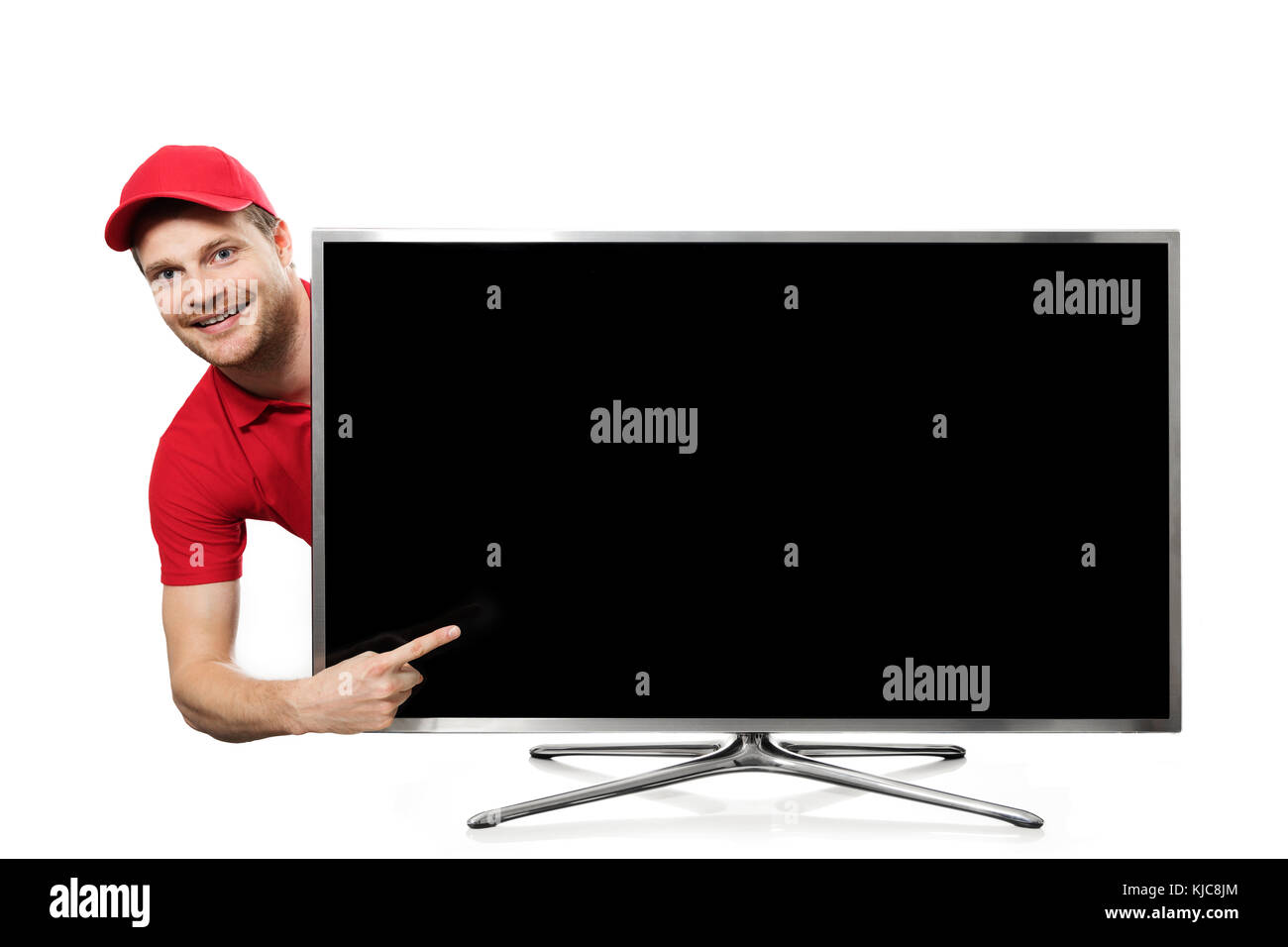 Jeune homme en uniforme rouge pointant sur l'écran de télévision vide Banque D'Images
