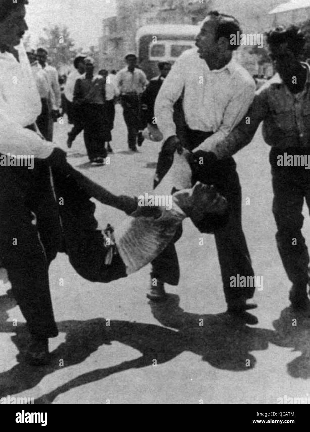 Les gens portent des jeunes blessés 21 Juillet 1953 Banque D'Images