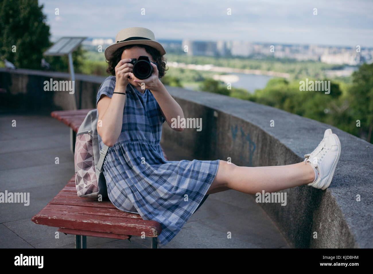 Caucasian woman sitting on bench photographier avec l'appareil photo Banque D'Images