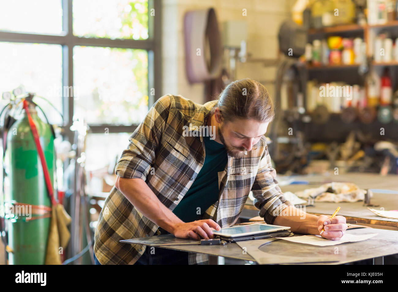 Caucasian man using digital tablet in workshop Banque D'Images