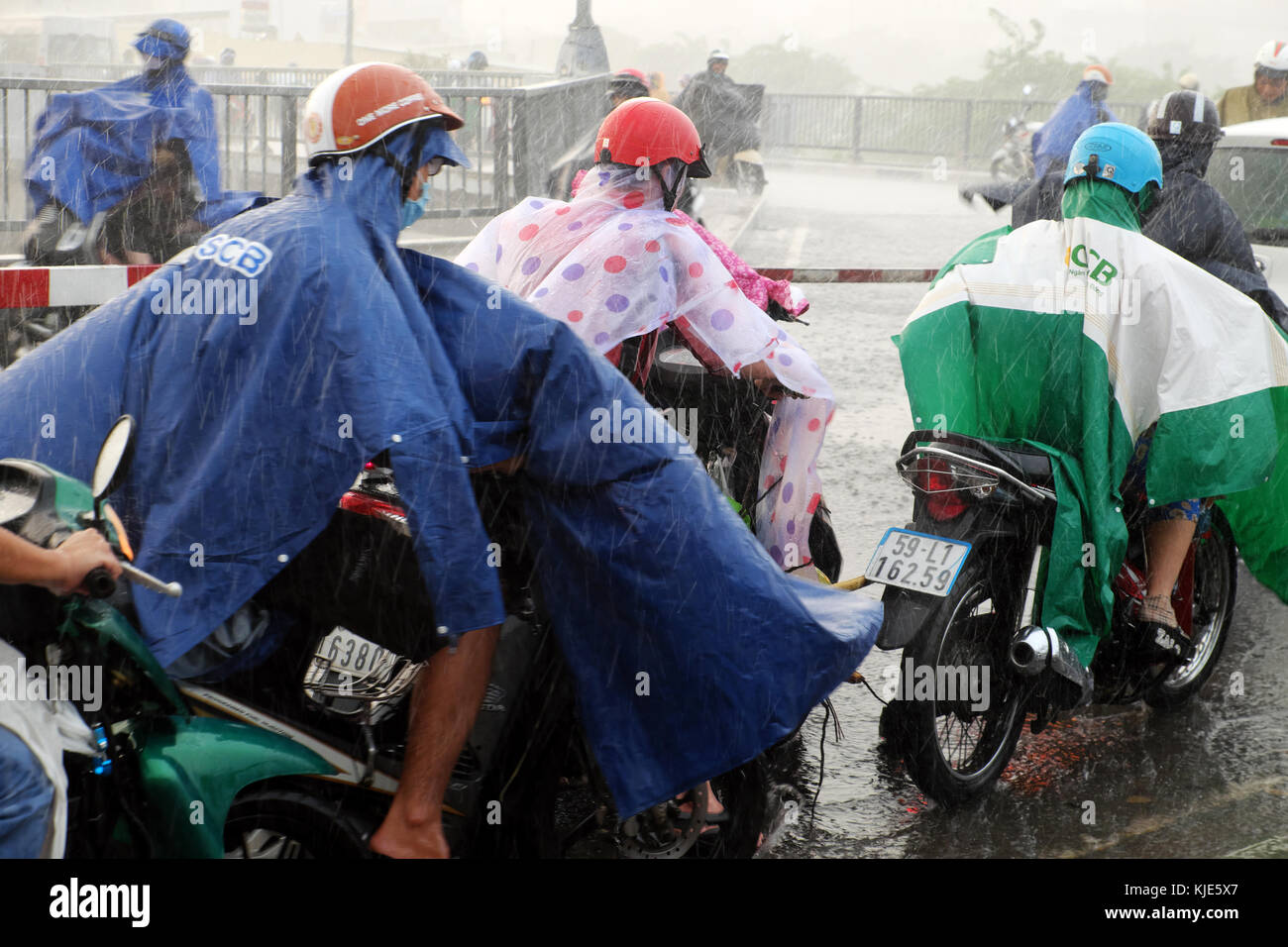 Ho chi minh ville, peuple asiatique ride moto, difficile de se déplacer dans de fortes pluies, des vents du mauvais temps Par basse pression après la tempête tropicale, le Viet Nam Banque D'Images