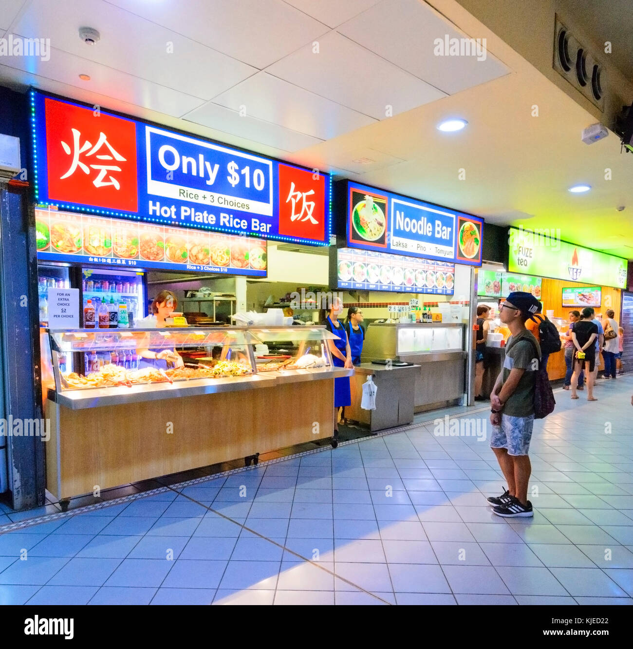 Garçon chinois à la recherche d'un magasin de vente à emporter de la nourriture chinoise, Cairns, Far North Queensland, Queensland, Australie, FNQ Banque D'Images
