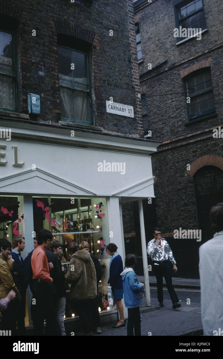 Les touristes de naviguer et d'acheter sur Carnaby street à l'ouest de Londres, Royaume-Uni, 1965. Banque D'Images