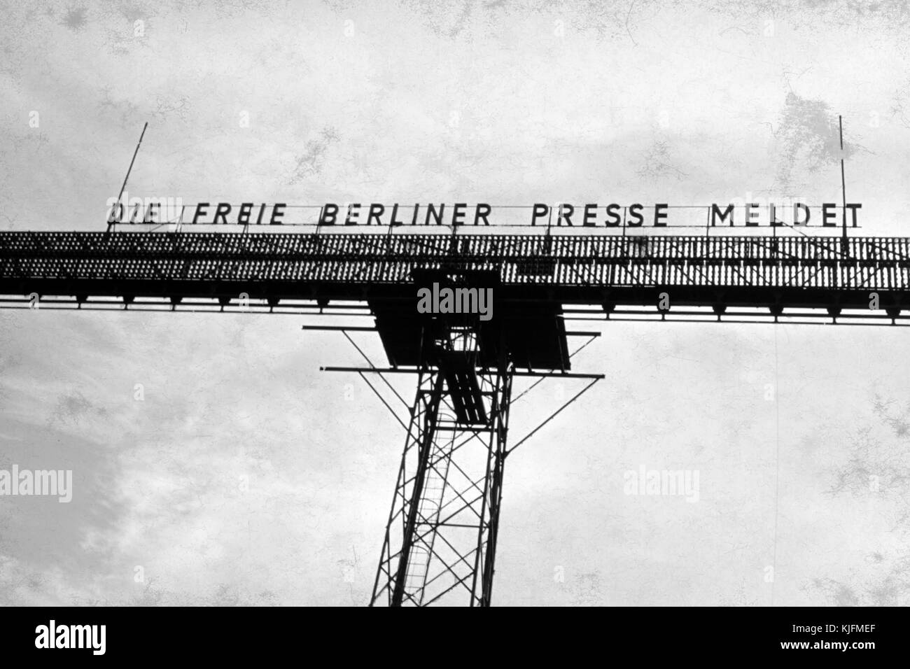 Vue de jour d'un téléscripteur géant allumé érigé à Berlin-Ouest pour envoyer des nouvelles et de la propagande à Berlin-est contrôlé par les Soviétiques, avec une pancarte indiquant « Die Freie Berliner presse Meldet » ou « annonçant la presse de Berlin libre » au-dessus de la partie allumée du téléscripteur, qui aurait été illuminé par des gros titres défilants la nuit, Allemagne, 1963. Banque D'Images