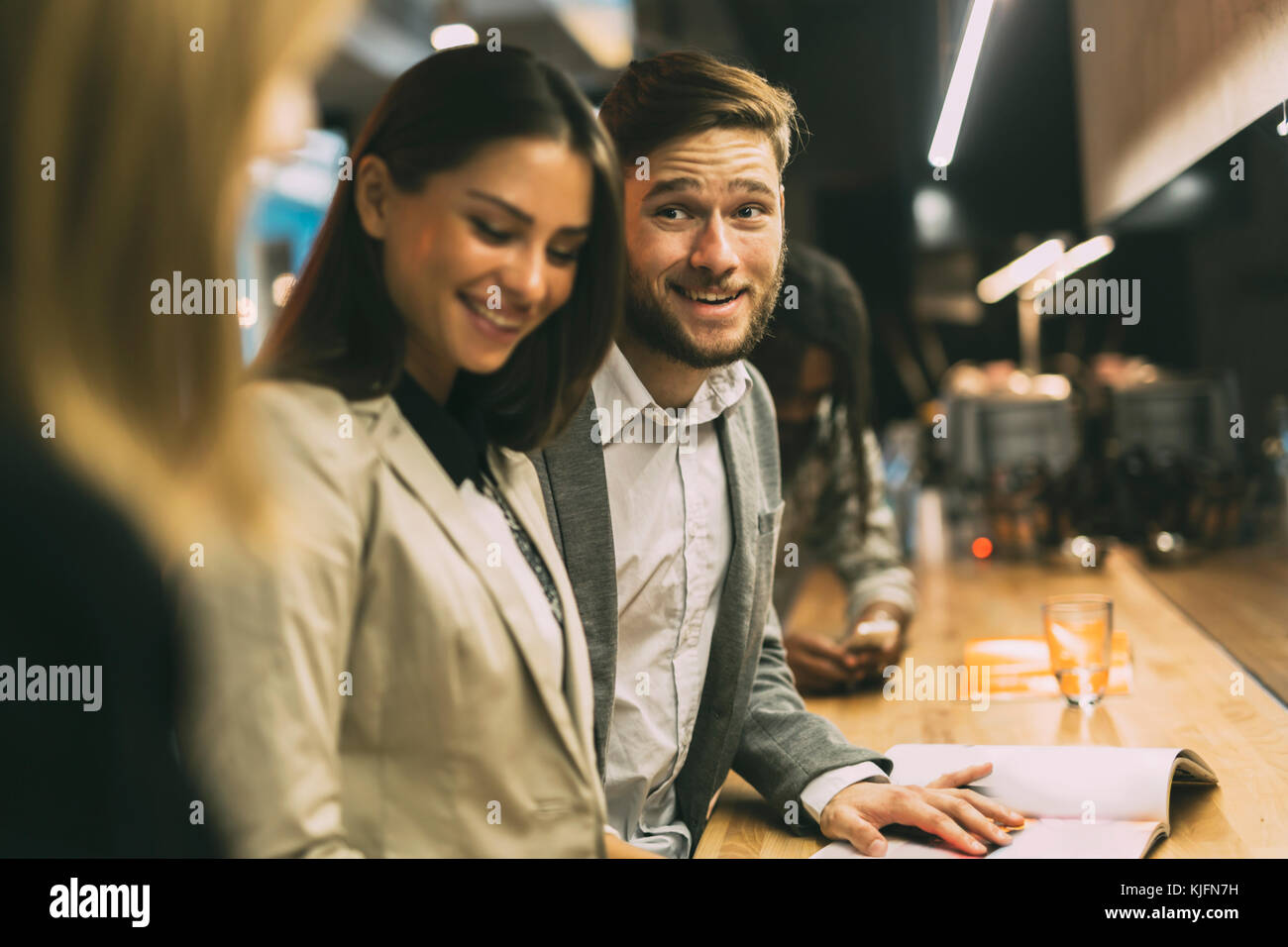 Les amis au comptoir d'un bar après le travail Banque D'Images