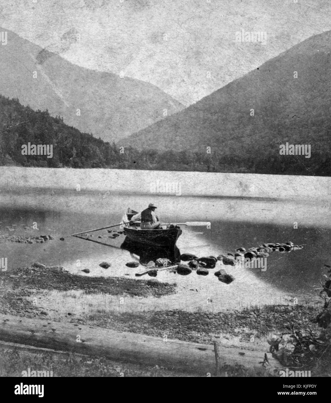 Photographie d'un homme en canoë, en eau peu profonde, montagnes en arrière-plan, intitulé 'Echo Lake et Franconia Notch, White Mountains', publié par Paul et Curtis, New Hampshire, 1865. De la bibliothèque publique de New York. Banque D'Images