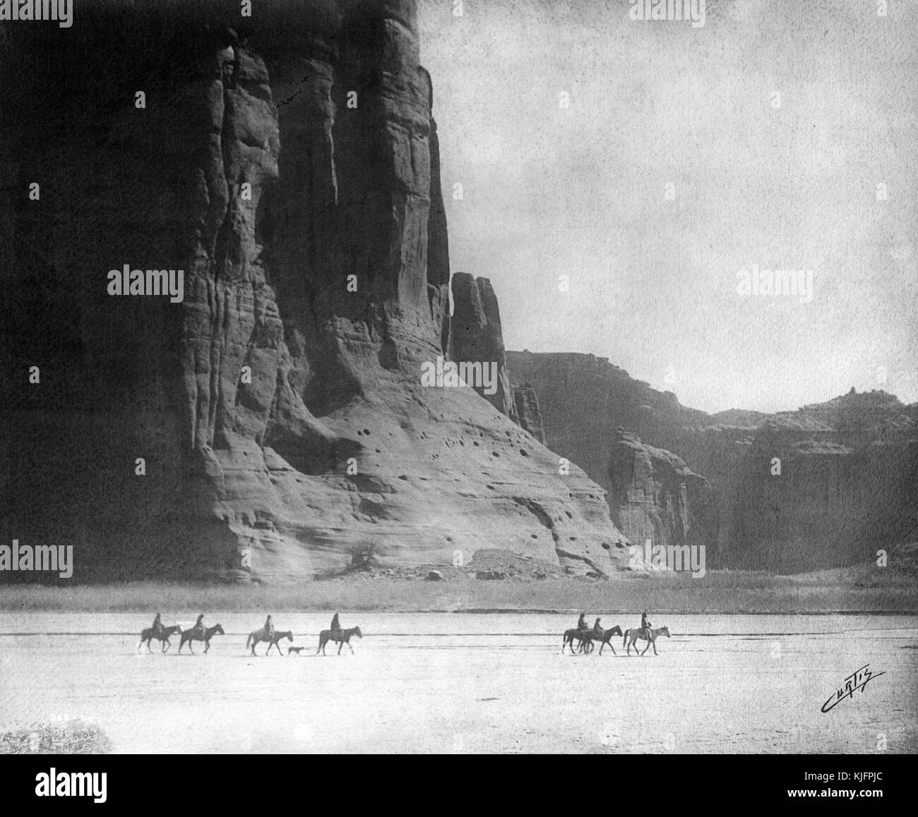 Photographie d'un groupe d'hommes monter à cheval dans le désert, en face du canyon de Chelly, intitulée 'canyon de Chelly (prononcer de shay)', par Edward s Curtis, Arizona, 1904. à partir de la bibliothèque publique de new york. Banque D'Images