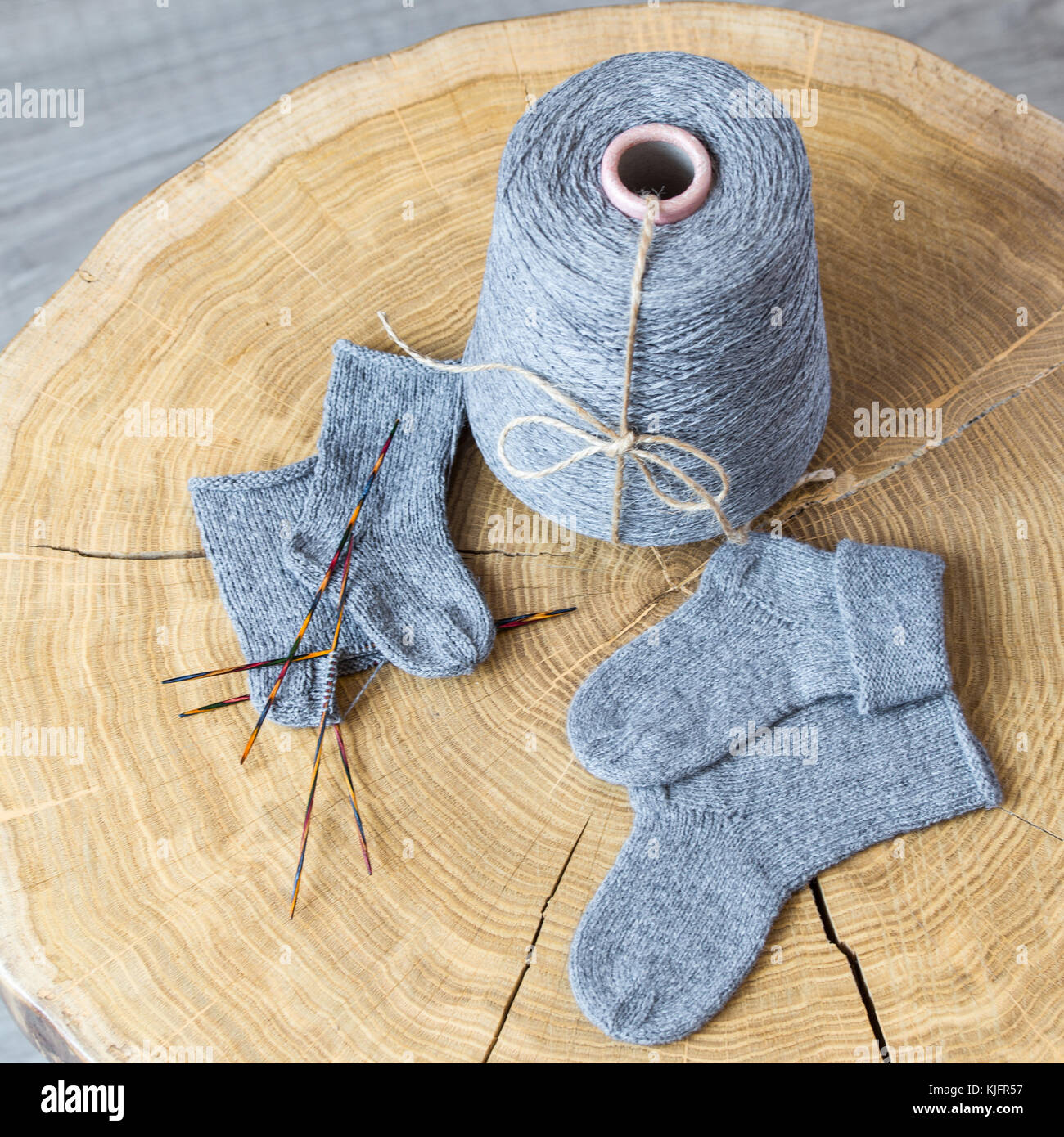 Cone Du Cachemire Duveteux Gris Aiguilles A Tricoter Et Chaussettes Bebe Nouveau Ne Sur Une Table Ronde En Bois Photo Stock Alamy
