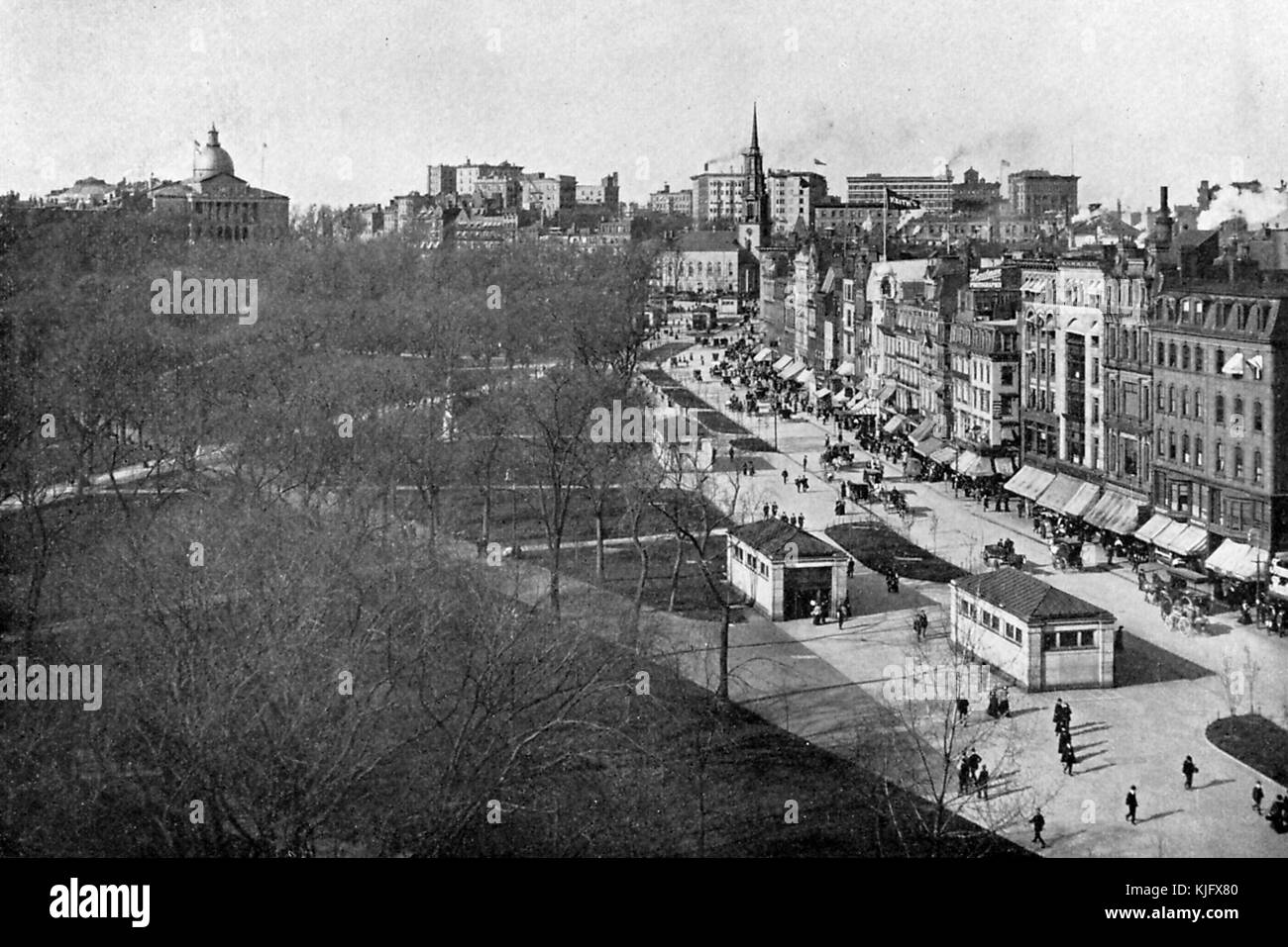 Une photo prise à partir d'une position élevée des entrées et sorties de la station de métro le long de Tremont Street à côté de Boston Common, l'herbe et les allées du parc peuvent être vues à travers les arbres qui sont stériles de feuilles, De nombreux bâtiments de la ville peuvent être vus le long de la rue et en arrière-plan, les gens marchent le long des trottoirs et des voitures de cheval sont en train de se déplacer le long de la rue, le développement de Boston Common a commencé en 1634, ce qui en fait le plus ancien parc public de la ville aux États-Unis, Boston, Massachusetts, 1905. Banque D'Images