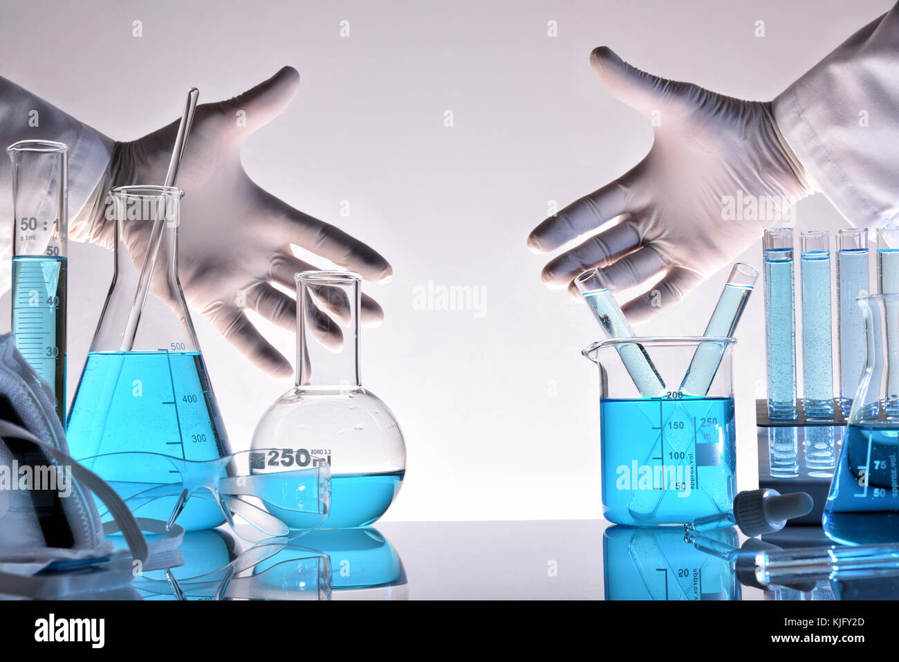 Fourniture d'équipement de laboratoire avec les contenants de verre et de protection sur une table et les mains avec des gants en arrière-plan. Compositio horizontale Banque D'Images