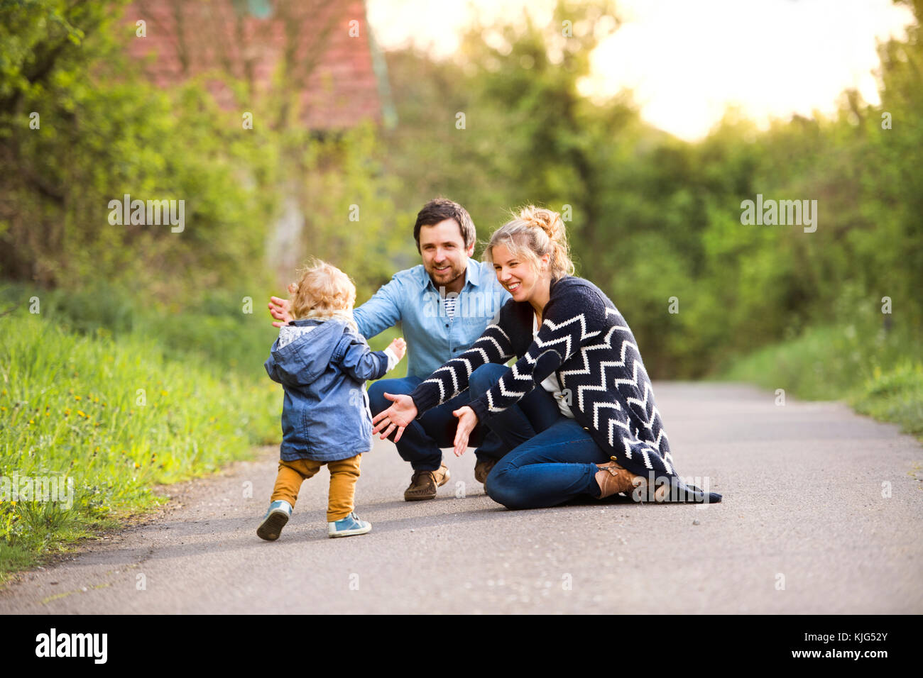 Petit garçon avec les parents sur le chemin de champ Banque D'Images