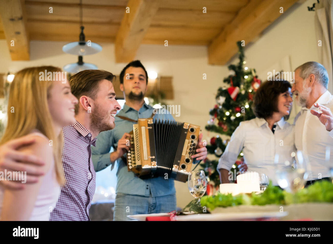 Jeune homme jouant de l'accordéon pour famille à Noël Photo Stock - Alamy