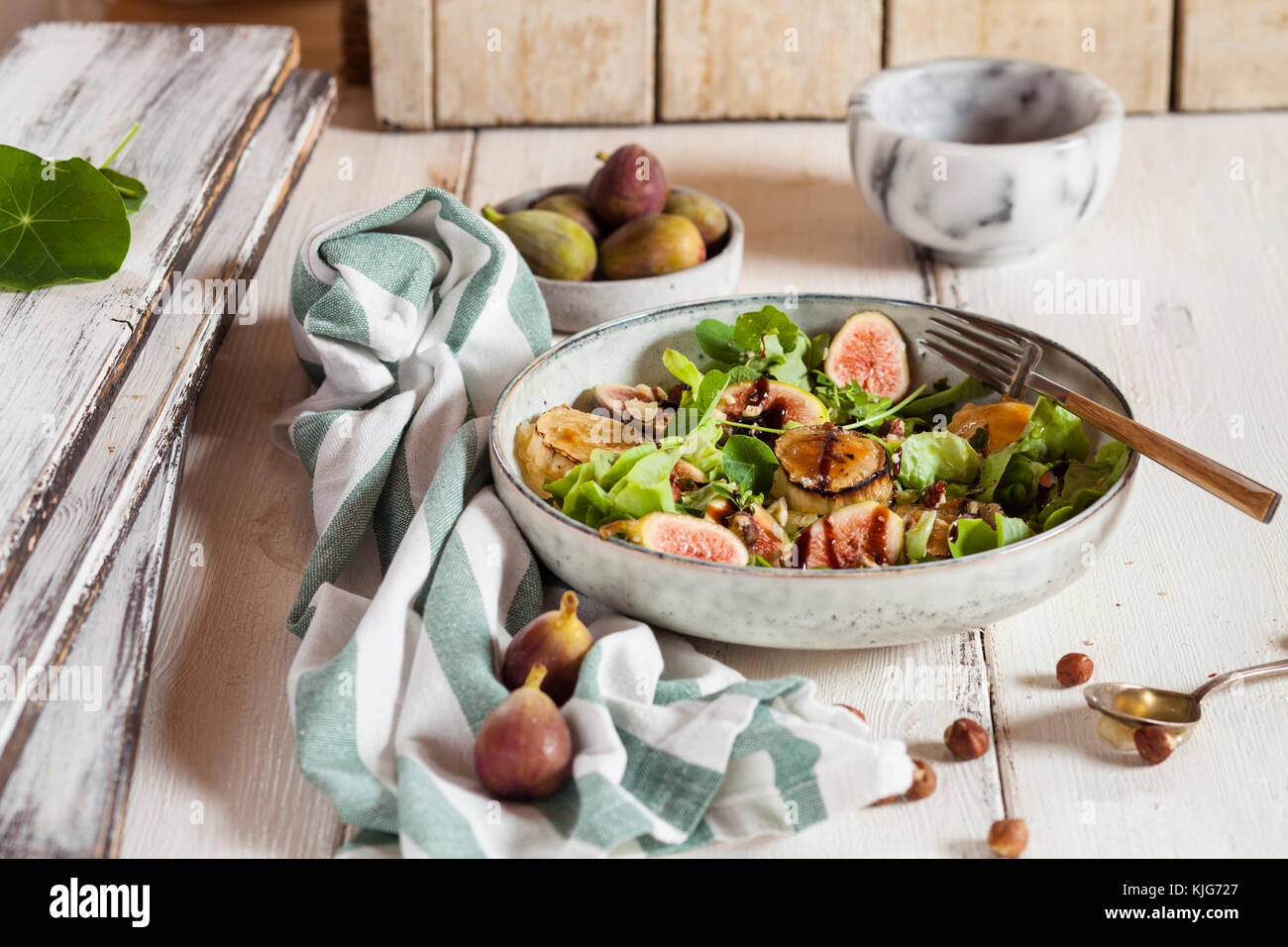 Assiette de salade verte avec des figues, Crema di Balsamico, miel noisettes et fromage de chèvre au four Banque D'Images