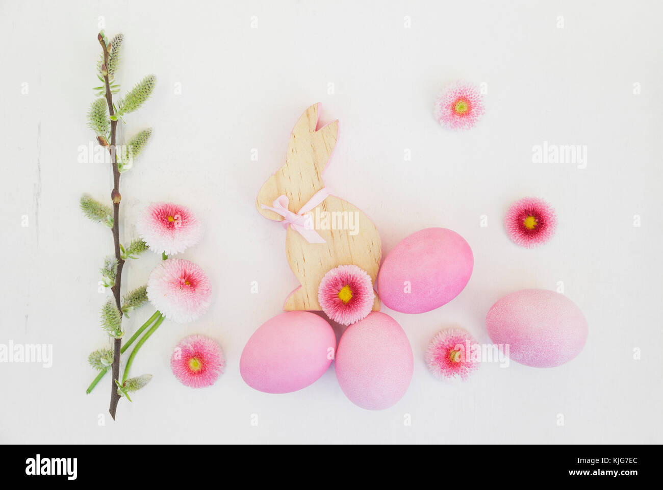 La main de rose l'oeufs de Pâques avec bunny, Daisy et décoration des chatons sur fond de bois Banque D'Images
