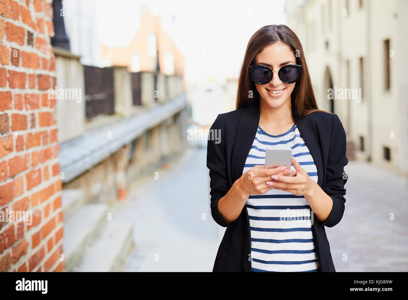 Jeune femme portant des lunettes de soleil à l'aide de l'extérieur Banque D'Images Jeune femme portant des lunettes de soleil à l'aide de l'extérieur Banque D'Images