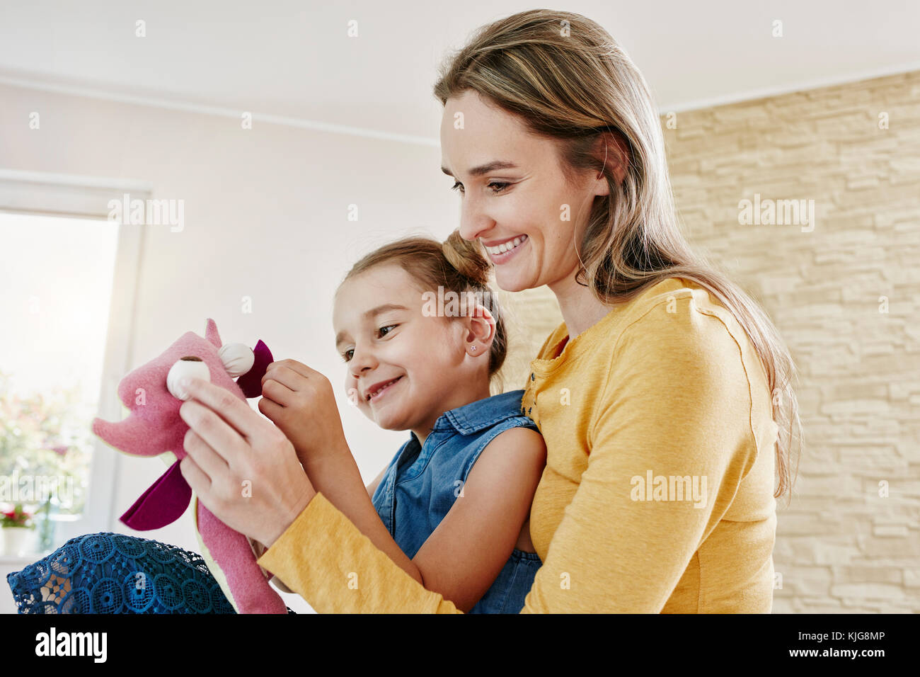 Heureuse mère et fille jouer avec à la maison adorable en peluche Banque D'Images