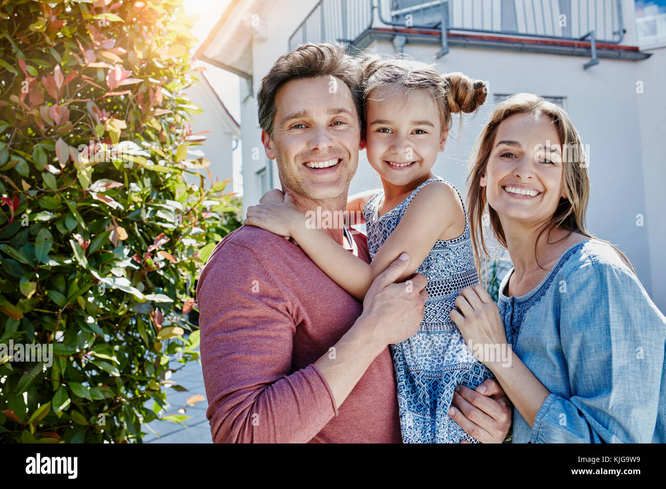 Portrait de famille heureuse devant leur maison Banque D'Images