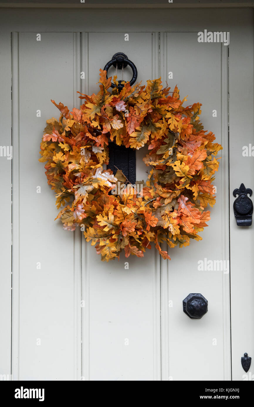 Automne tissu feuille de chêne couronne sur la porte d'un chalet dans la région des Cotswolds, Gloucestershire, Angleterre Banque D'Images