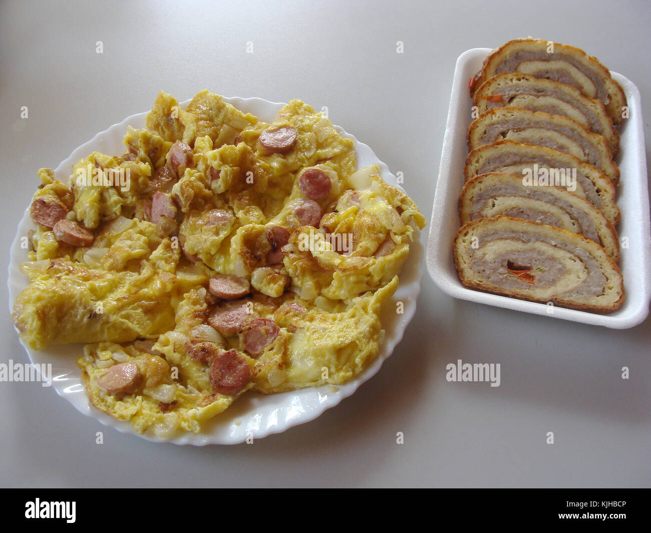 Omelette avec saucisses et viandes sur roulette table gris Banque D'Images