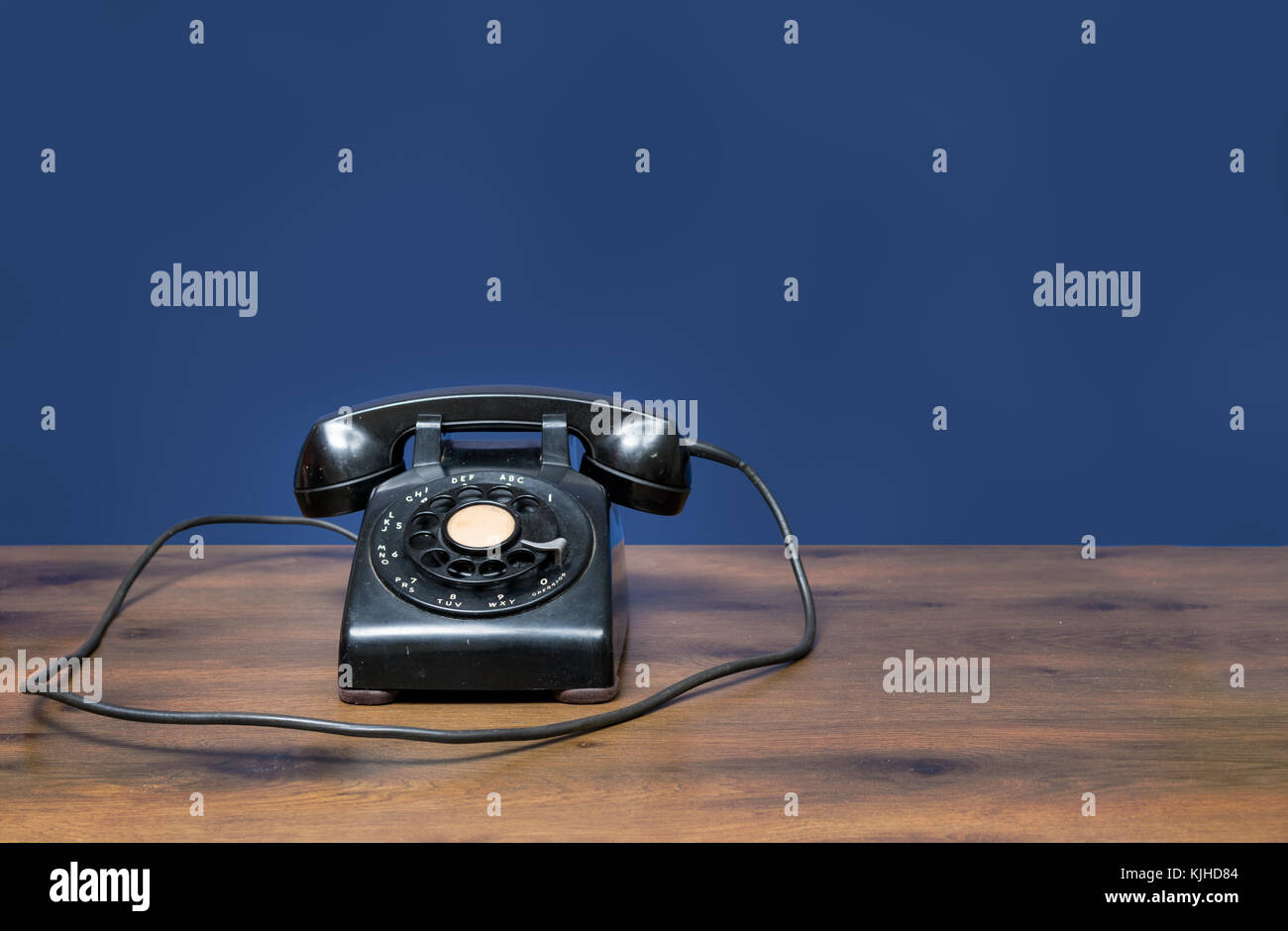 Mobilier ancien téléphone à cadran rotatif sur un bureau en bois Banque D'Images