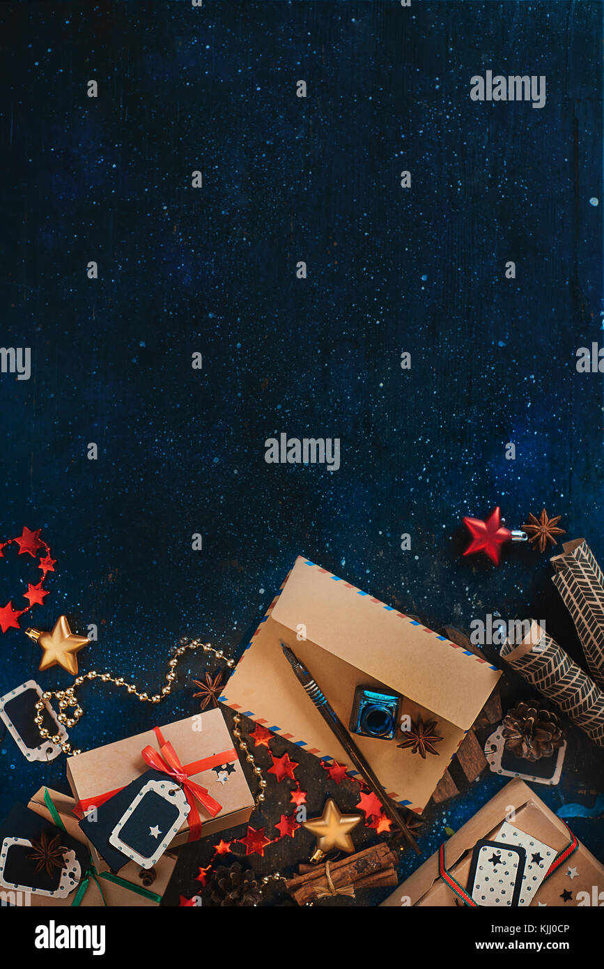 Lettre au Père Noël craft concept enveloppe avec décorations de Noël et gifts. Nouvel an fête dark flat fixer avec du papier craft, boîtes de sta Banque D'Images