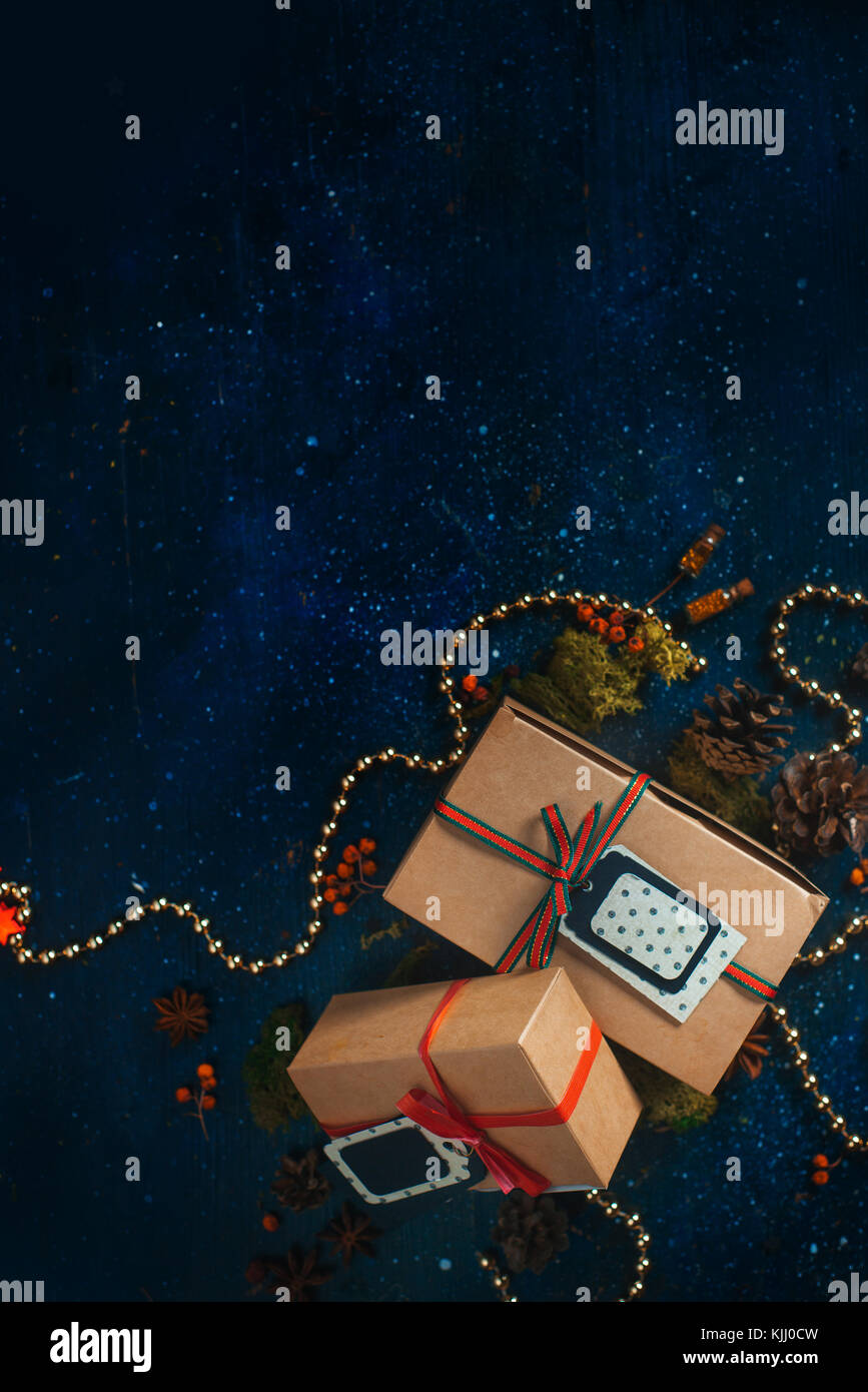 Cadeaux de Noël et décorations. gifts concept. fête de Noël dark flat fixer avec des boîtes en papier craft, étoiles, tags, guirlandes et Banque D'Images