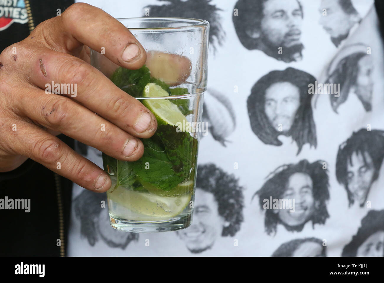 Un homme portant un t-shirt Bob Marley & boire un mojito. La France. Banque D'Images