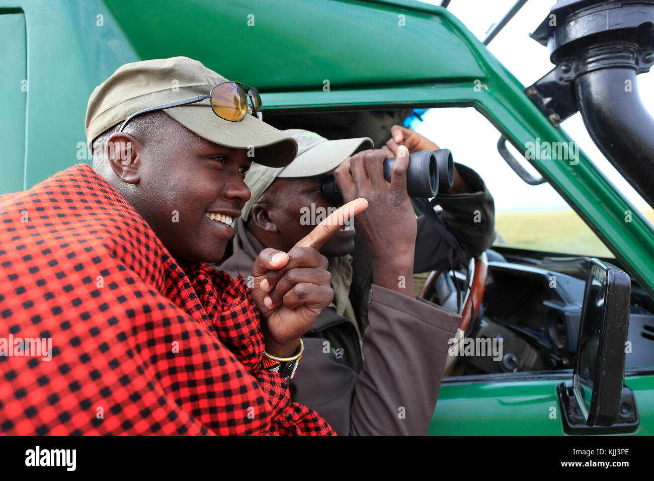 Guide Masai recherche jeu à travers les jumelles. Le Masai Mara. Au Kenya. Banque D'Images