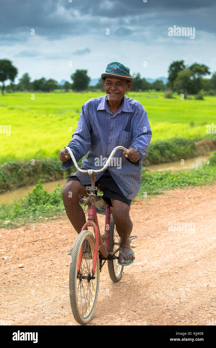 Le Khmer de la bicyclette sur une route de campagne. Le Cambodge. Banque D'Images