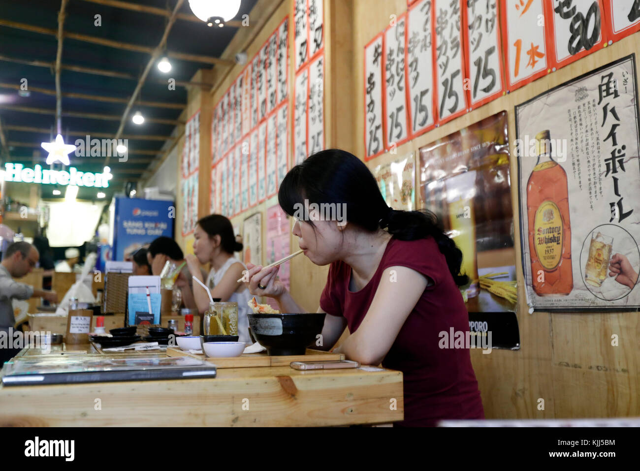 Woamn prenant le déjeuner dans un restaurant japonais. Ho Chi Minh Ville. Le Vietnam. Banque D'Images