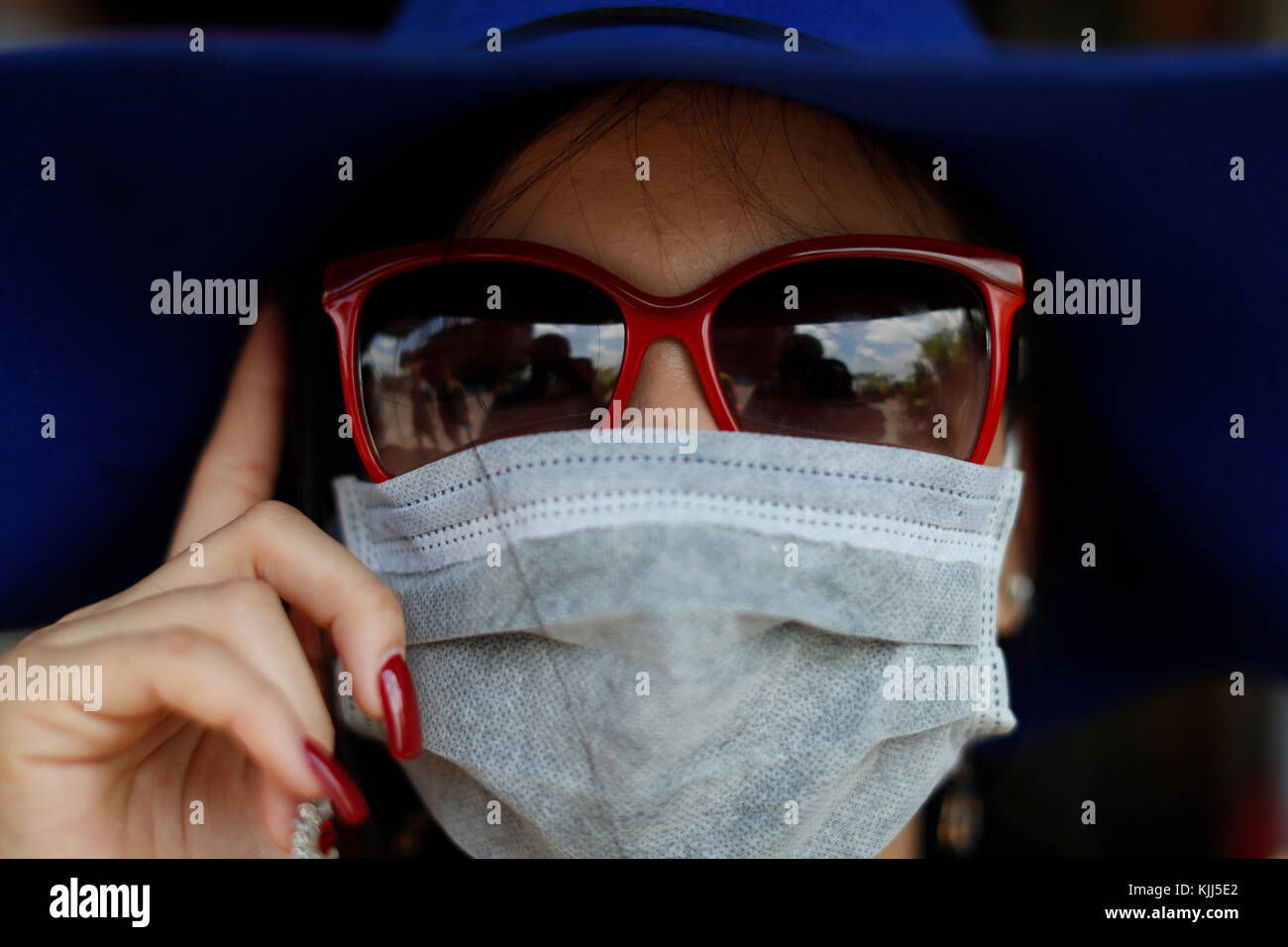 Vietnamienne avec lunettes de soleil et masque. Notre annuaire d'entreprises. Le Vietnam. Kon Tum. Le Vietnam. Banque D'Images
