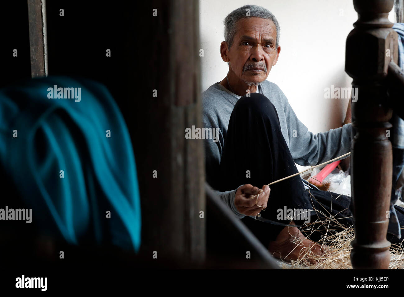 Ba Na (Bahnar) groupe ethnique. Vieil homme à l'aide de dessiner sur le bois. Kon Tum. Le Vietnam. Banque D'Images