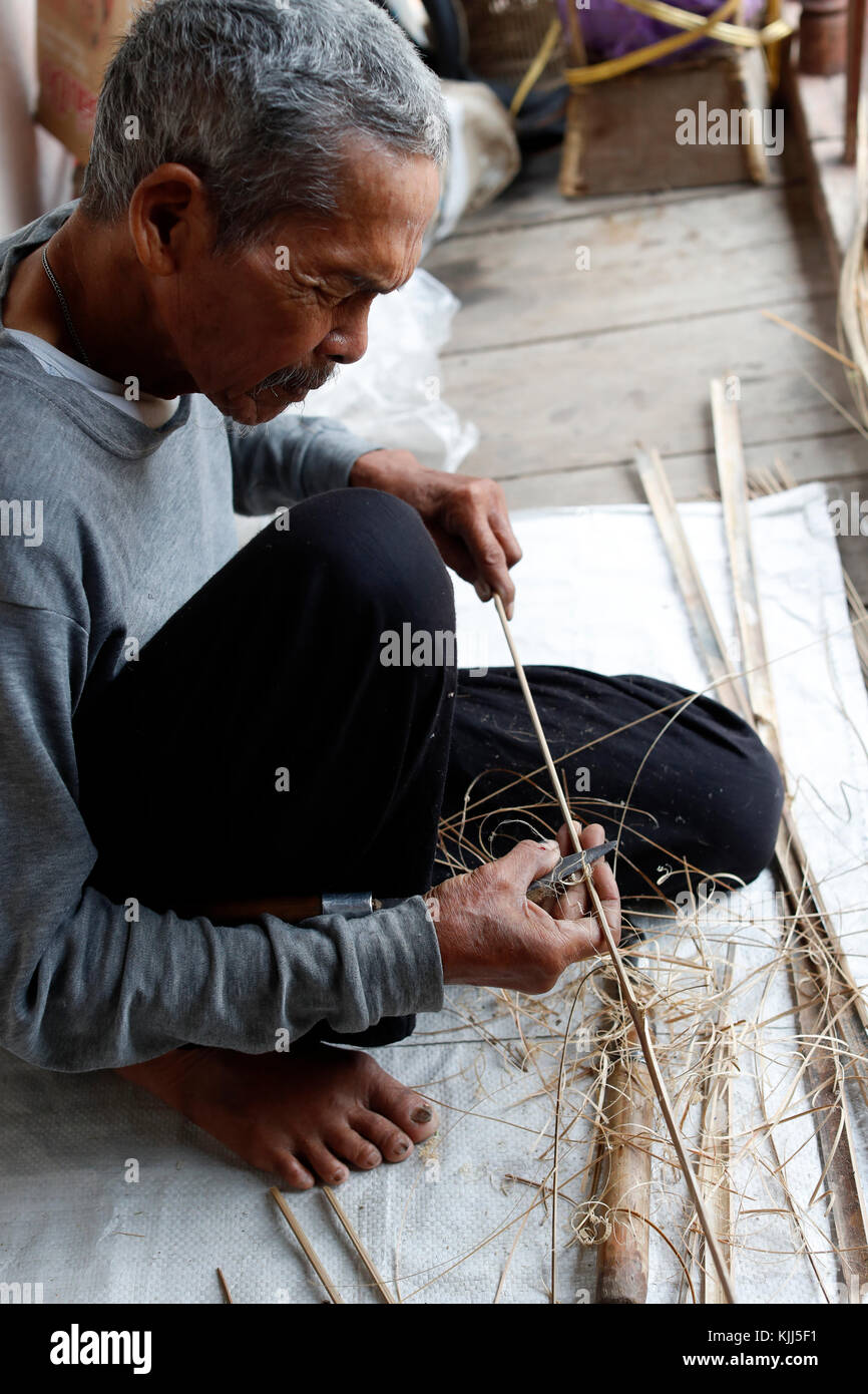 Ba Na (Bahnar) groupe ethnique. Vieil homme à l'aide de dessiner sur le bois. Kon Tum. Le Vietnam. Banque D'Images